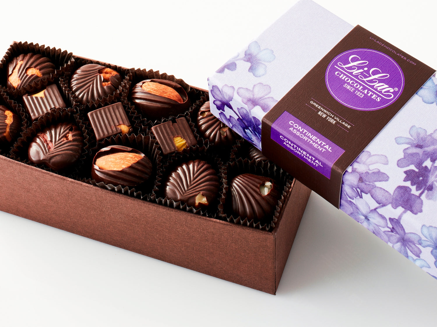 A rectangular box of chocolate with a brown base and a purple lid with watercolor lilac motifs.