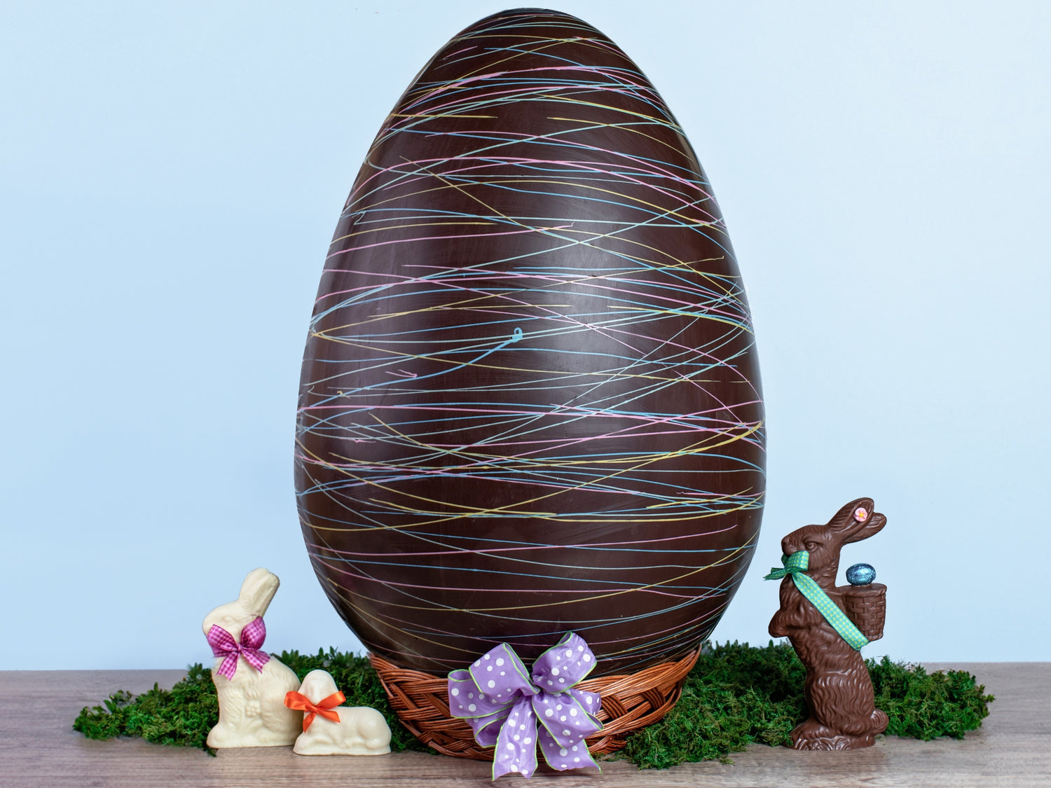 a very large chocolate egg decorated with colorful drizzle