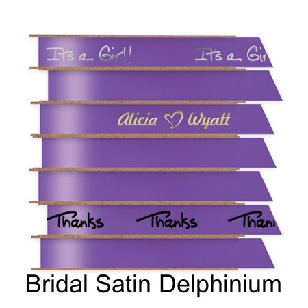 A stack of seven spools of shiny delphinium satin ribbon with custom messages printed on them in different colors.