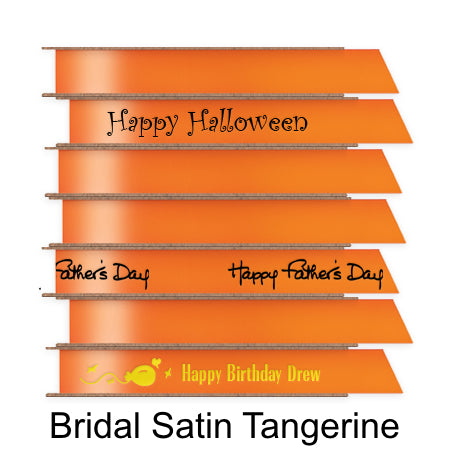 A stack of seven spools of shiny tangerine orange satin ribbon with custom messages printed on them in different colors.
