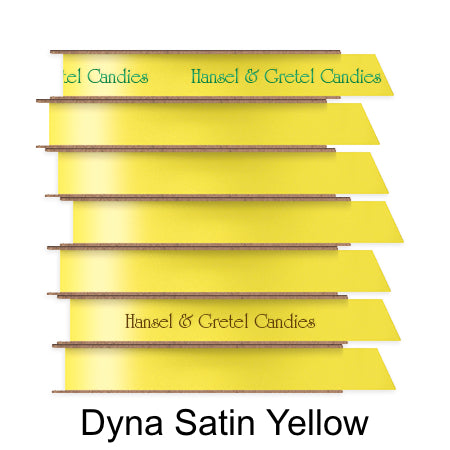 A stack of seven spools of shiny bright yellow satin ribbon with custom messages printed on them in different colors.