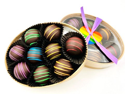 An oval box of 9 chocolate truffles decorated in rainbow colors.