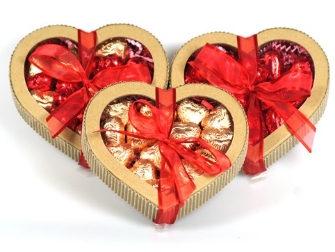 Kraft paper chocolate hearts are filled with foil wrapped chocolate hearts and the box is tied with a festive ribbon.