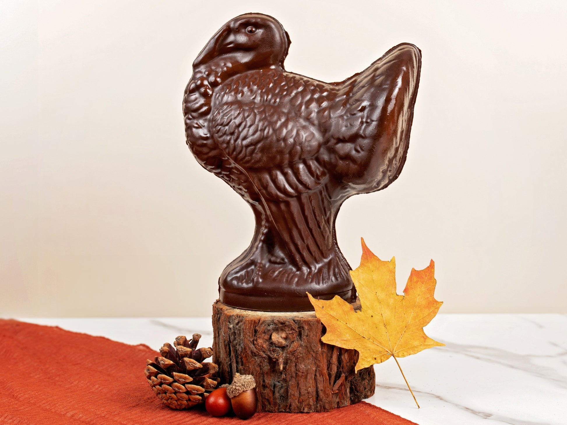 A dark chocolate turkey standing proud on a slice of tree branch