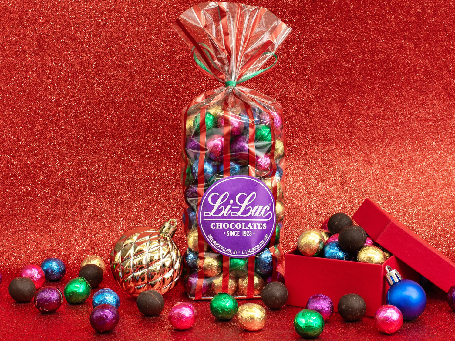 A clear bag filled with colorful chocolate balls in assorted foil colors