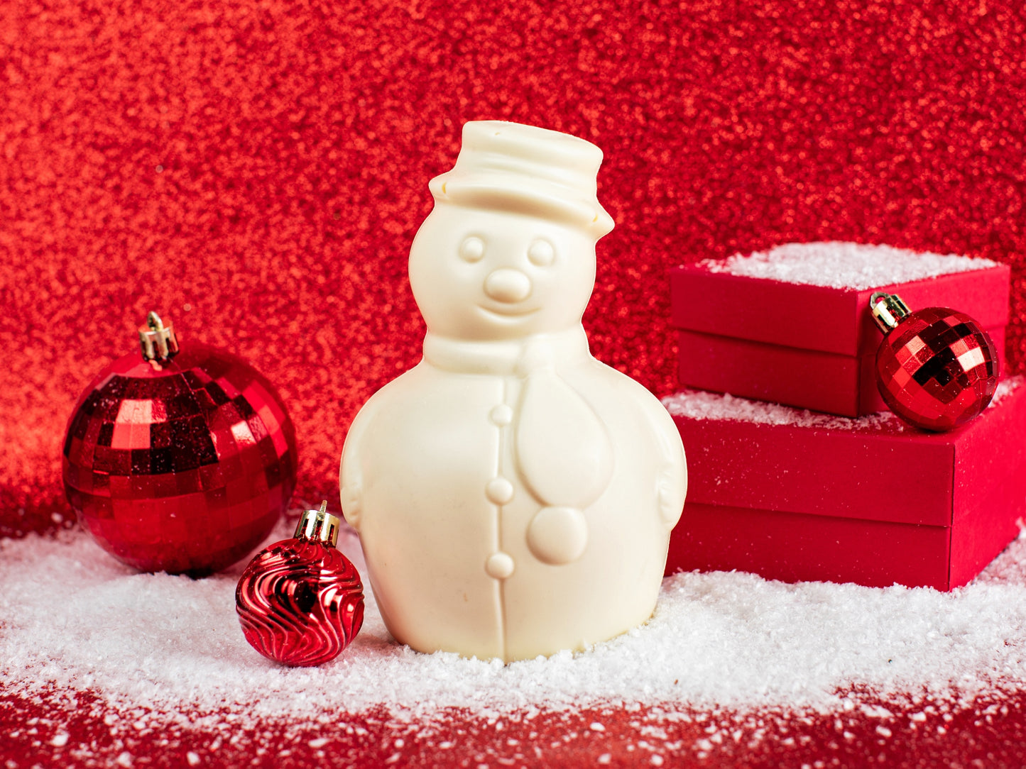 A molded white chocolate snowman with a top hat and scarf