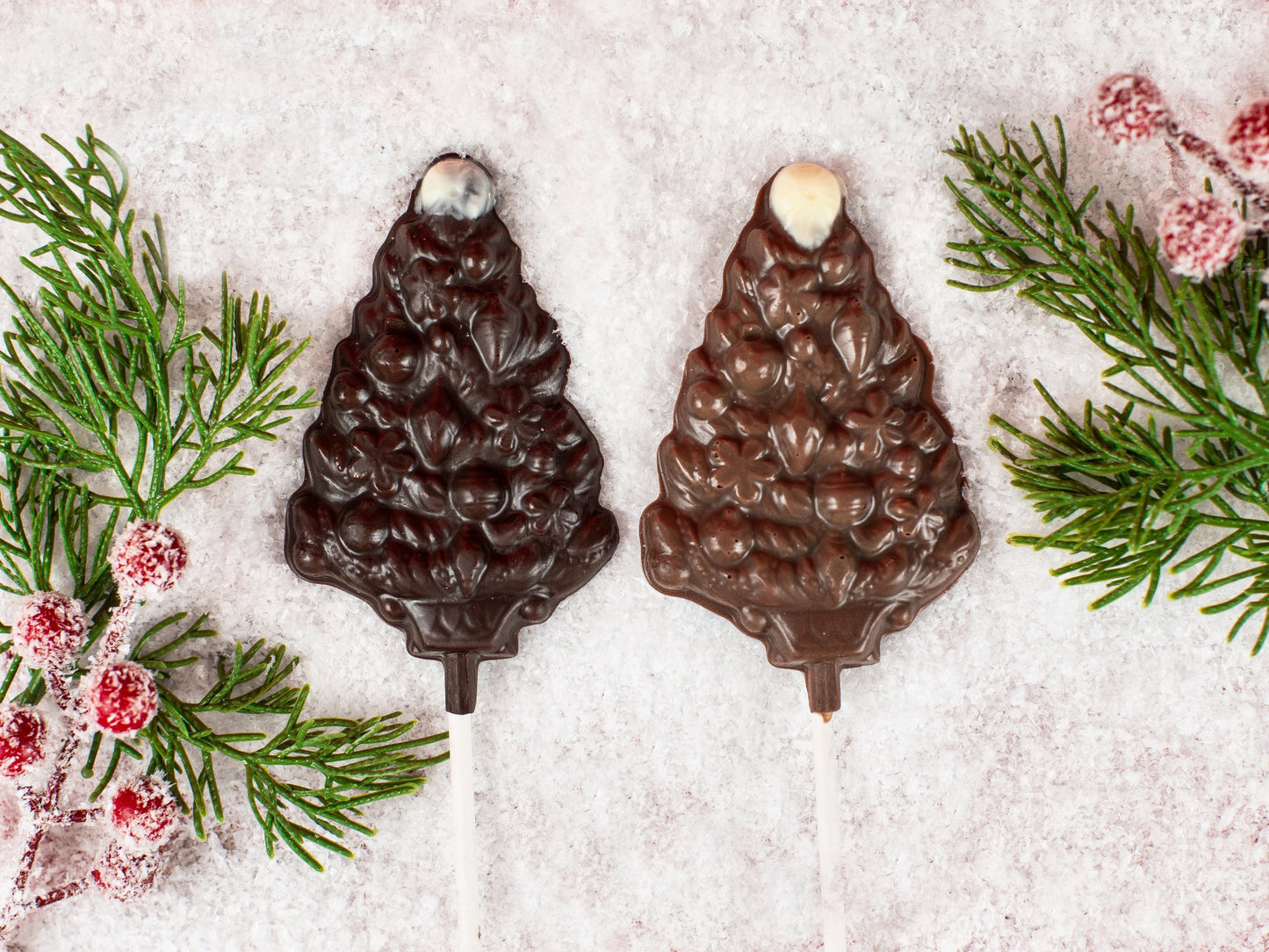 Two molded chocolate evergreen tree pops on a stick.