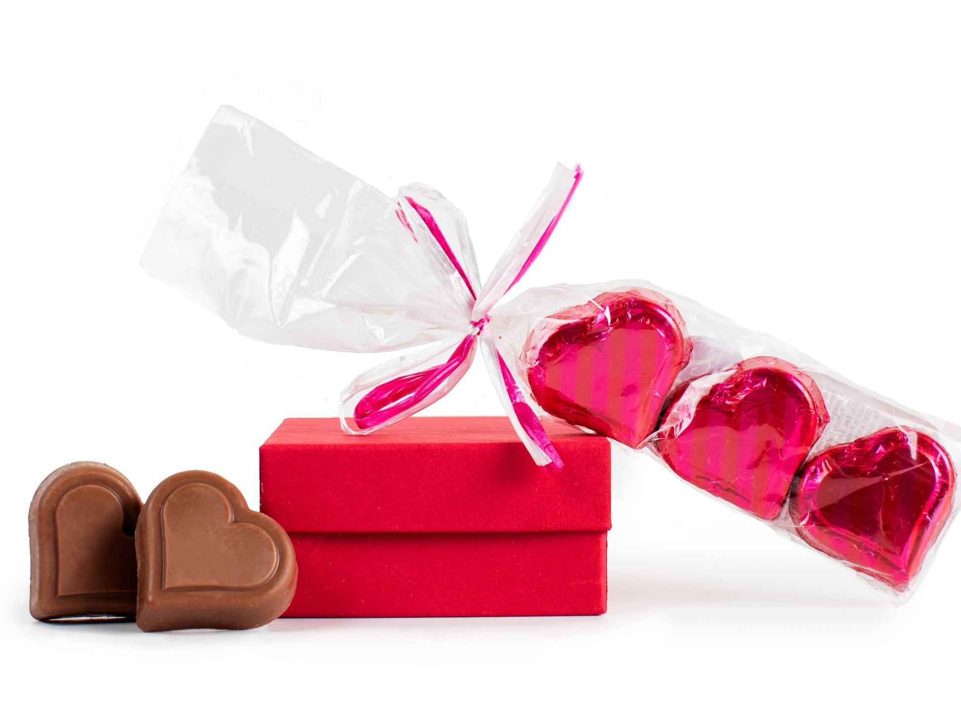 three foiled PB hearts on a small red box next to two unwrapped peanut butter hearts.