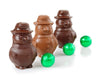 Round little tiny molded chocolate snowmen next to foil wrapped chocolate balls. 