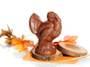 A four inch tall chocolate molded turkey stands with a fanned out tail.
