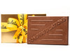 A large rectangular chocolate bar as the word 'Congratulations' written on it. It comes in a gold gift box with a yellow ribbon with Congratulations written on the ribbon in black script. 