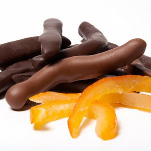 Pieces of candied, glace orange peel, enrobed in dark or milk chocolate sit together.