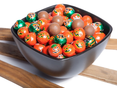 Cute little chocolate balls are foil wrapped to look like vintage jack-o-lanterns and black halloween cats.